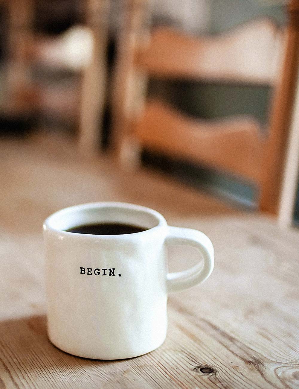 Eine Kaffeetasse mit einem Wort drauf. "BEGIN."